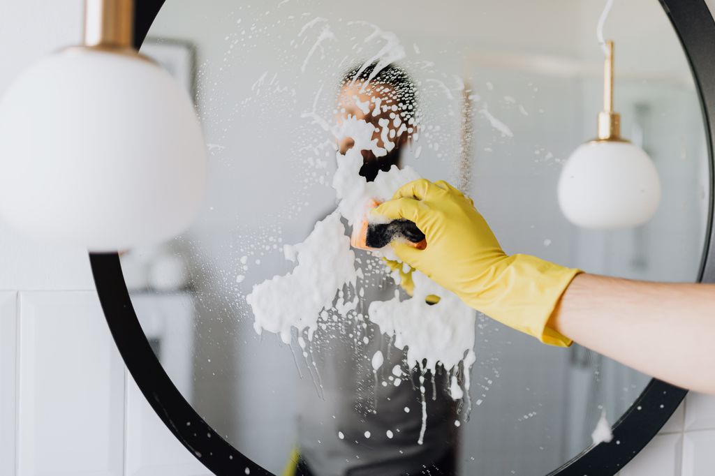 A man cleaning a mirror