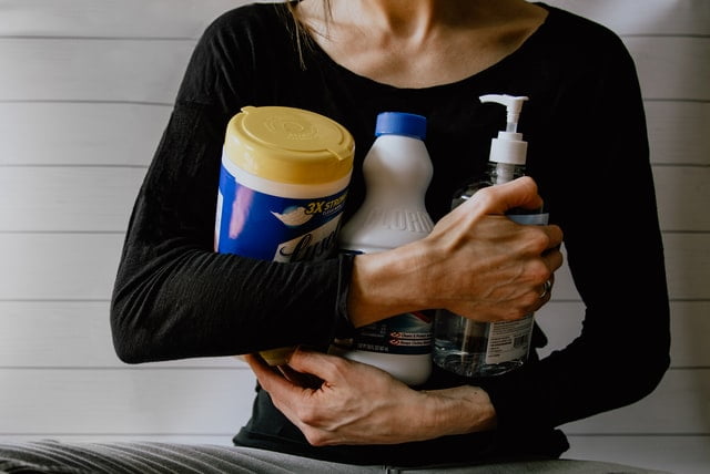 A woman holding cleaning products