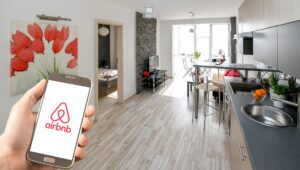 Hand with Airbnb app in home