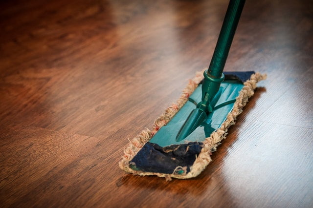 Cleaning the floors with a mop.