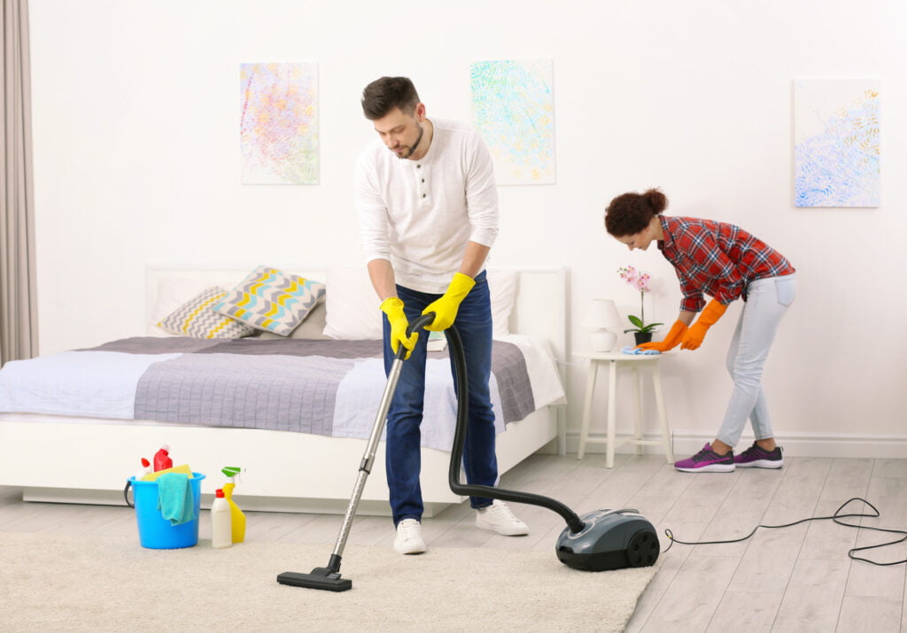 Couple Cleaning Bedroom