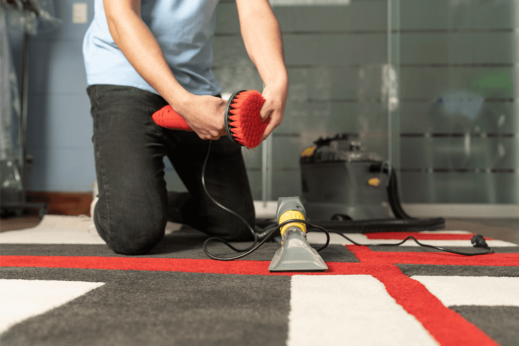 Specialized cleaning techniques examples.
Person holding power scrubber with other tools on carpet.