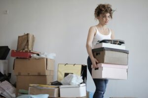 A woman holding a boxes of things they getting rid of to help declutter a home.